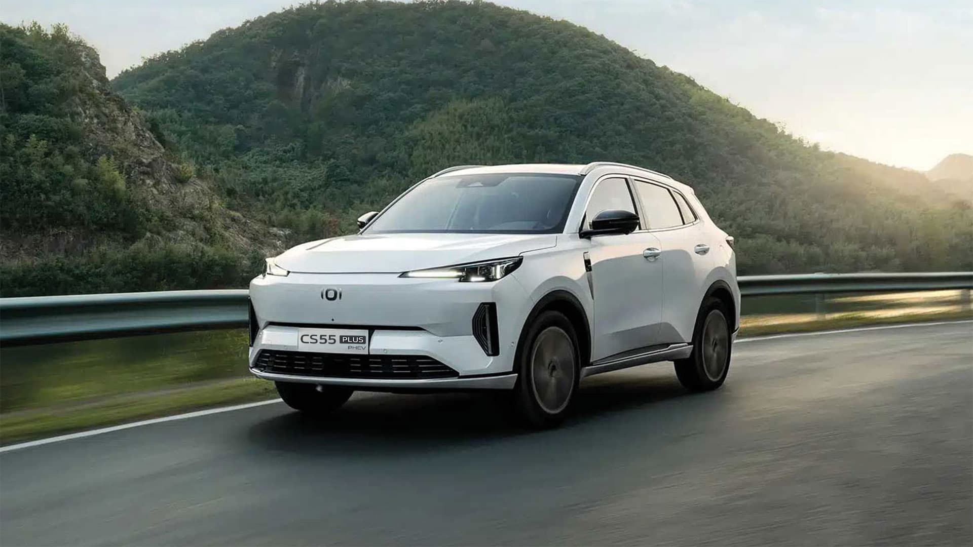 A blue Changan CS55 driving on a coastal road at dusk.